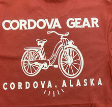 Brick Red t-shirt with white bicycle graphic and 'Cordova Gear Cordova, Alaska' 