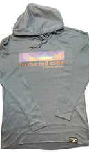 Blue hoodie with a fish, northern lights and “in the red zone, Cordova, Alaska” text on a washed indigo surface