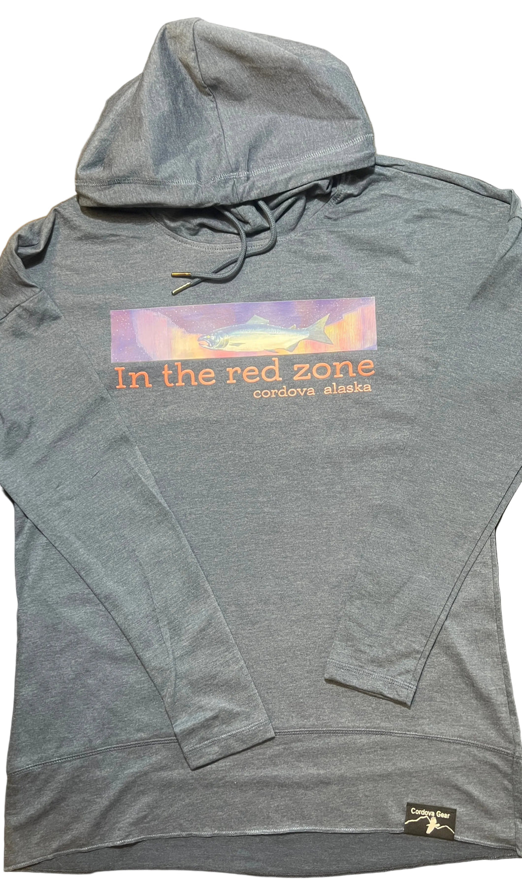 Blue hoodie with a fish, northern lights and “in the red zone, Cordova, Alaska” text on a washed indigo surface